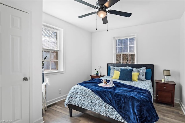 bedroom featuring visible vents, ceiling fan, baseboards, and wood finished floors