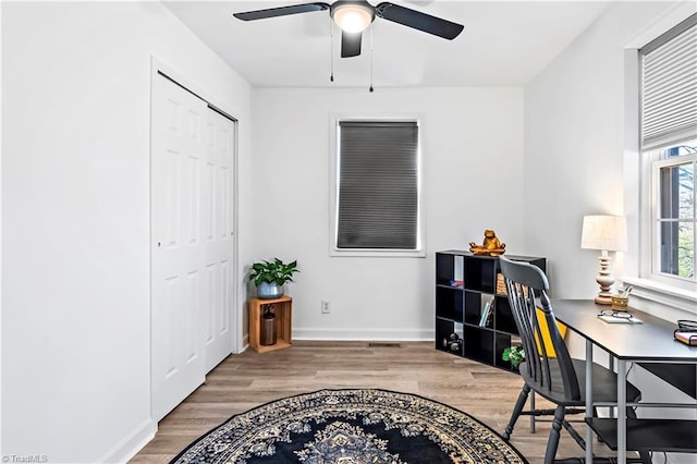 office space featuring wood finished floors, baseboards, and ceiling fan