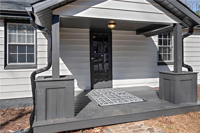 entrance to property featuring a shingled roof