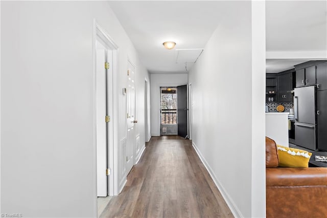 corridor with attic access, baseboards, and wood finished floors