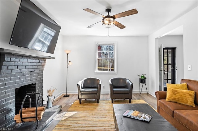 living room with plenty of natural light, a fireplace, light wood-type flooring, and baseboards