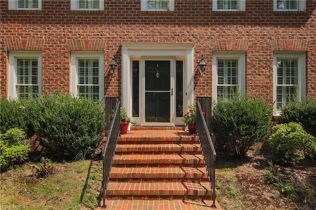 entrance to property featuring brick siding