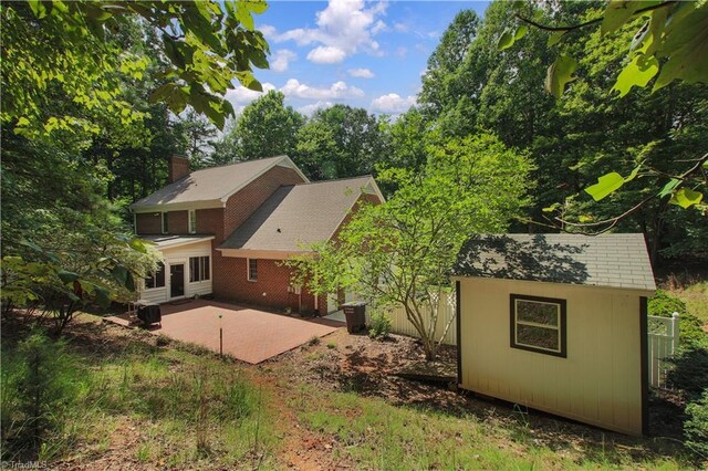 view of side of property with an outdoor structure and a patio area