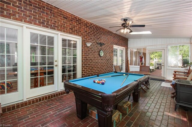 rec room featuring billiards, ceiling fan, vaulted ceiling, and brick wall