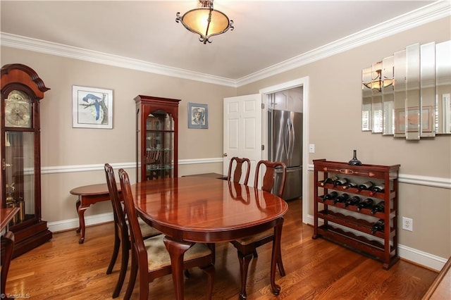 dining room with ornamental molding and dark hardwood / wood-style floors