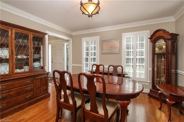 dining area featuring crown molding and hardwood / wood-style flooring