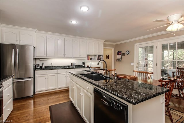 kitchen with black dishwasher, ornamental molding, freestanding refrigerator, white cabinets, and a sink