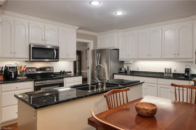 kitchen featuring stainless steel appliances, white cabinetry, a sink, and ornamental molding