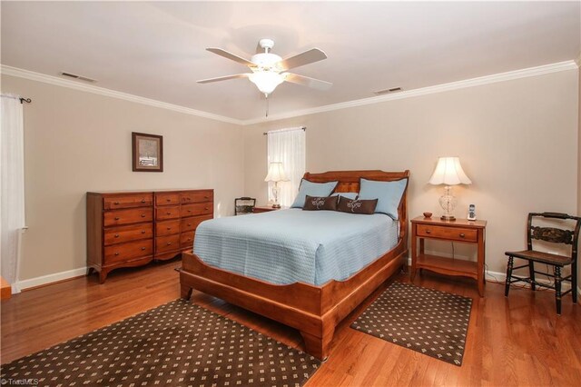 bedroom featuring ceiling fan, hardwood / wood-style flooring, and ornamental molding