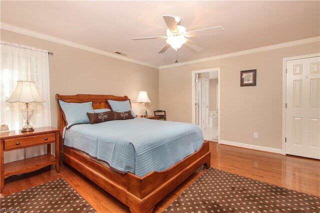 bedroom featuring crown molding, ceiling fan, ensuite bath, and wood-type flooring