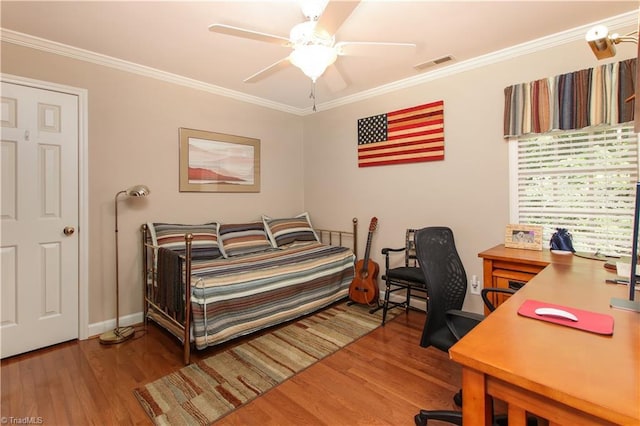 bedroom featuring ornamental molding, visible vents, and wood finished floors