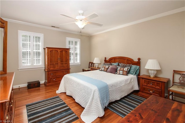 bedroom with visible vents, wood finished floors, and ornamental molding