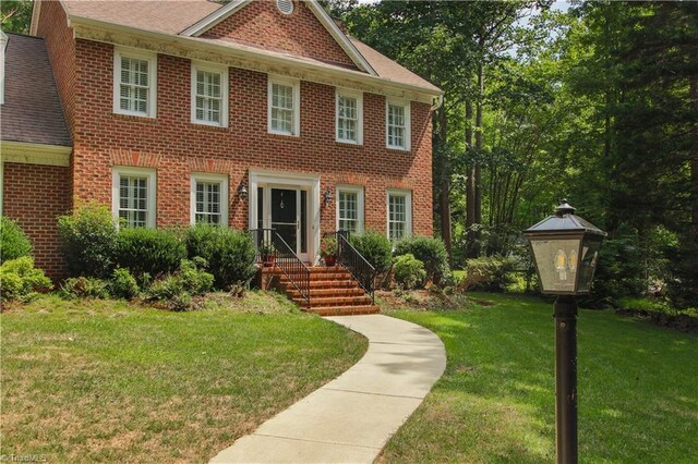 colonial inspired home with a front lawn