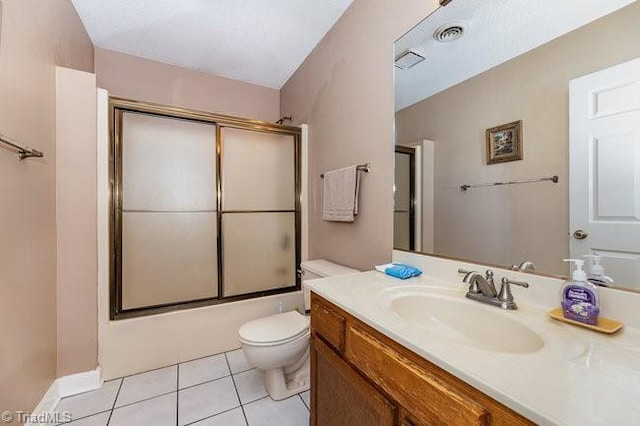 full bathroom with toilet, vanity, bath / shower combo with glass door, and tile patterned flooring