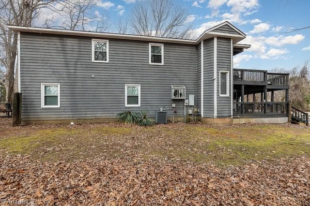 rear view of house with central AC, a lawn, and a deck