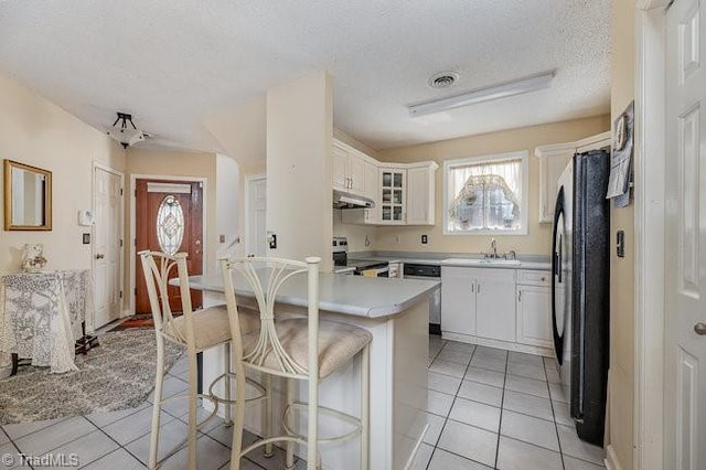 kitchen featuring appliances with stainless steel finishes, a breakfast bar, sink, and white cabinets