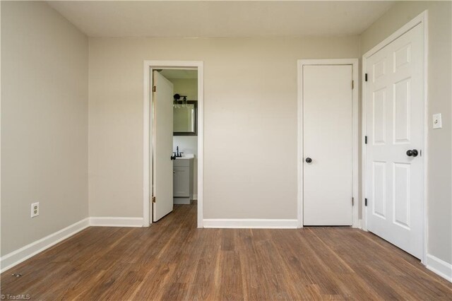 4362 Parsonsville Rd, Purlear, NC 28665 - unfurnished bedroom featuring baseboards, wood finished floors, and a sink