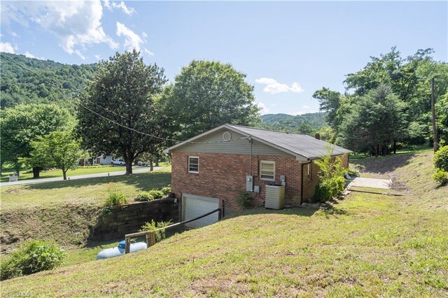 4362 Parsonsville Rd, Purlear, NC 28665 - view of side of property with a garage, central air condition unit, brick siding, and a lawn