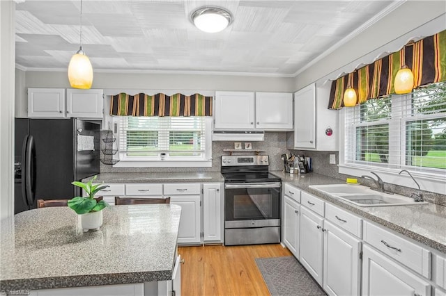 kitchen with white cabinetry, sink, a center island, black fridge, and stainless steel range with electric stovetop