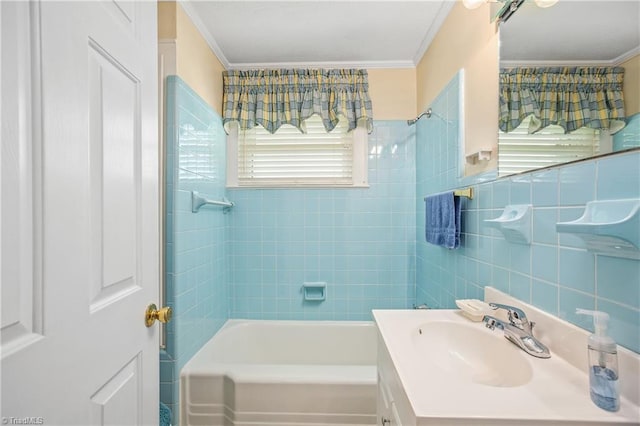 bathroom featuring vanity, ornamental molding, tile walls, and tiled shower / bath combo