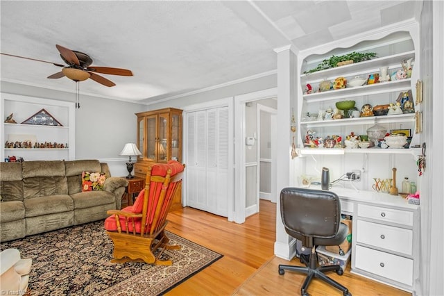 interior space featuring ceiling fan, wood-type flooring, and ornamental molding