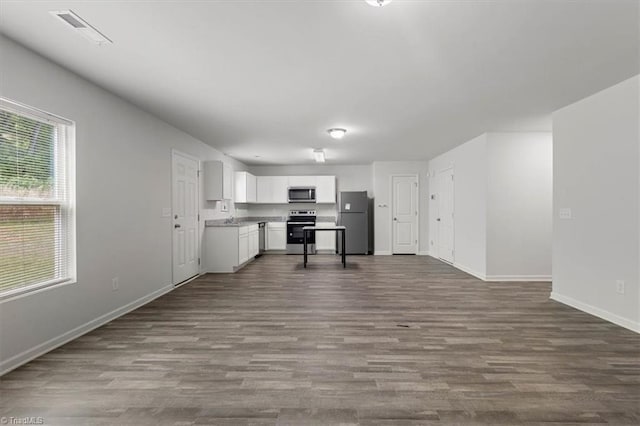kitchen with appliances with stainless steel finishes, visible vents, dark wood-style floors, baseboards, and open floor plan
