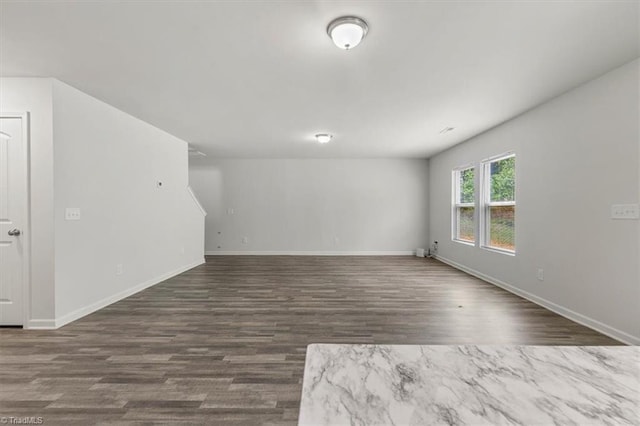 unfurnished room with dark wood finished floors and baseboards