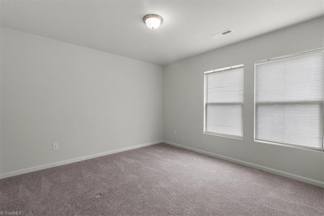 unfurnished room featuring carpet floors and baseboards