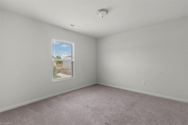 carpeted spare room featuring baseboards
