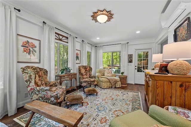 living area with wood finished floors, plenty of natural light, a wall unit AC, and recessed lighting