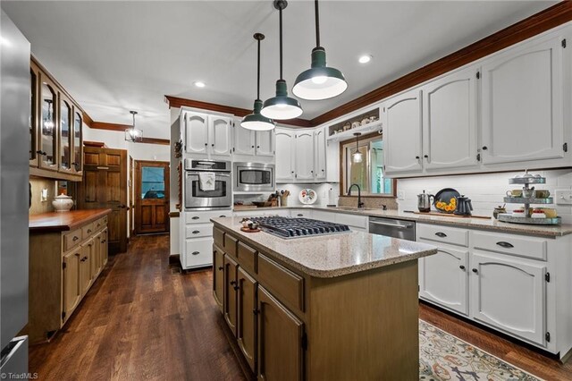 kitchen with dark wood-style floors, a sink, a center island, backsplash, and appliances with stainless steel finishes