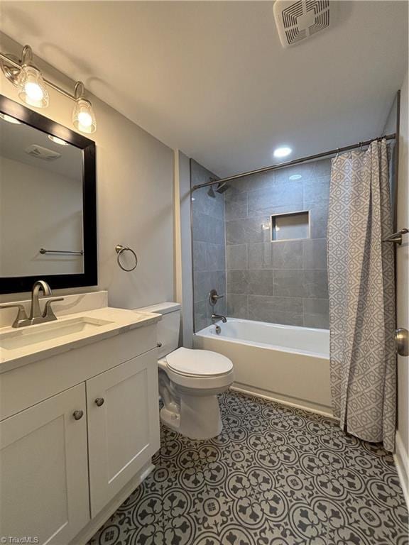 full bathroom featuring tile patterned floors, shower / bath combo with shower curtain, vanity, and toilet