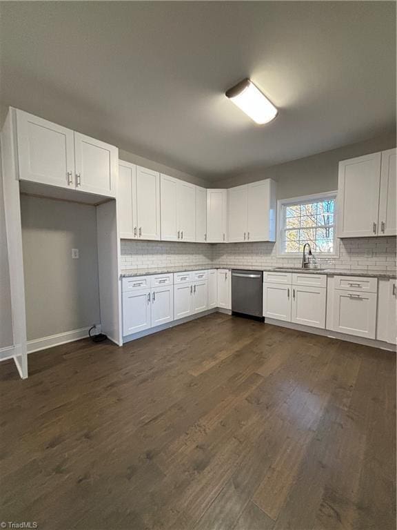 kitchen with dark hardwood / wood-style flooring, backsplash, stainless steel dishwasher, sink, and white cabinets