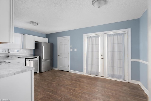 kitchen featuring dark wood-type flooring, white cabinets, sink, a textured ceiling, and appliances with stainless steel finishes