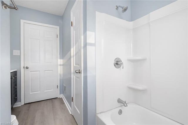 bathroom featuring shower / washtub combination, vanity, and hardwood / wood-style flooring