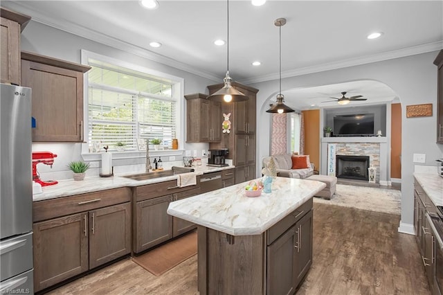 724-0 Tom Cook Rd, Pilot Mountain, NC 27041 - kitchen featuring appliances with stainless steel finishes, a ceiling fan, a fireplace, open floor plan, and crown molding