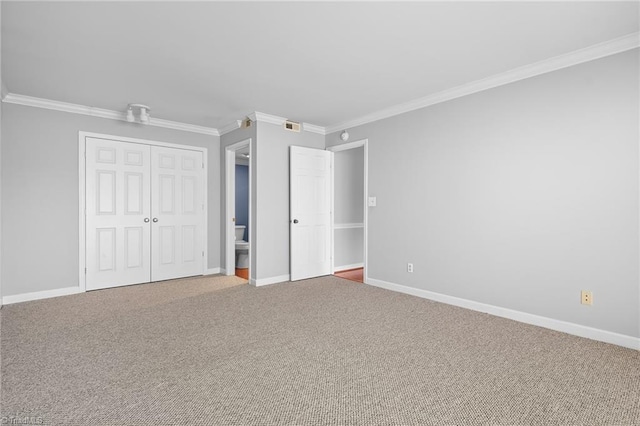 unfurnished bedroom featuring baseboards, crown molding, and carpet