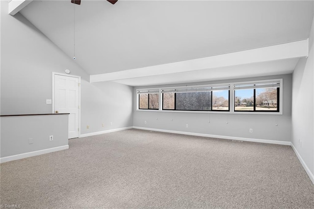 carpeted empty room with a healthy amount of sunlight, high vaulted ceiling, baseboards, and a ceiling fan