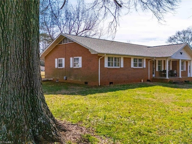 view of home's exterior featuring crawl space, brick siding, a lawn, and roof with shingles