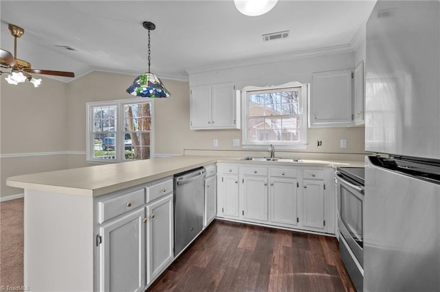 kitchen featuring visible vents, light countertops, a peninsula, stainless steel appliances, and a sink