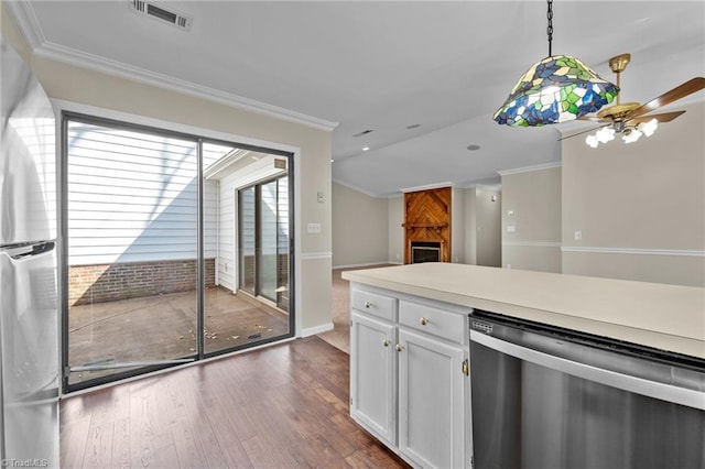 kitchen featuring visible vents, ornamental molding, dark wood-style floors, appliances with stainless steel finishes, and a fireplace