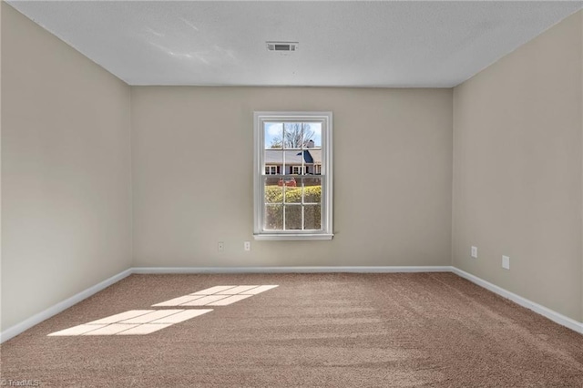 carpeted empty room with baseboards and visible vents