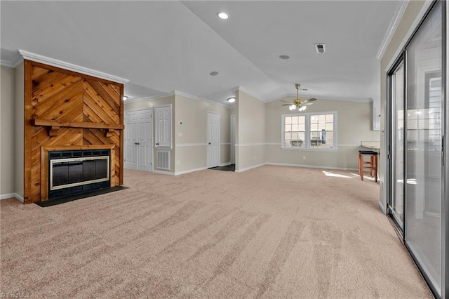 unfurnished living room with baseboards, lofted ceiling, a fireplace, light carpet, and crown molding