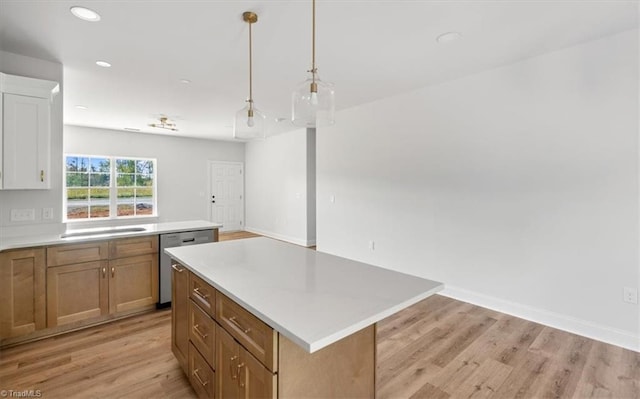 kitchen featuring light hardwood / wood-style flooring, dishwasher, sink, decorative light fixtures, and a center island