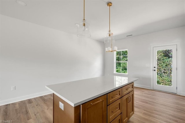 kitchen featuring a chandelier, a center island, decorative light fixtures, and light hardwood / wood-style floors