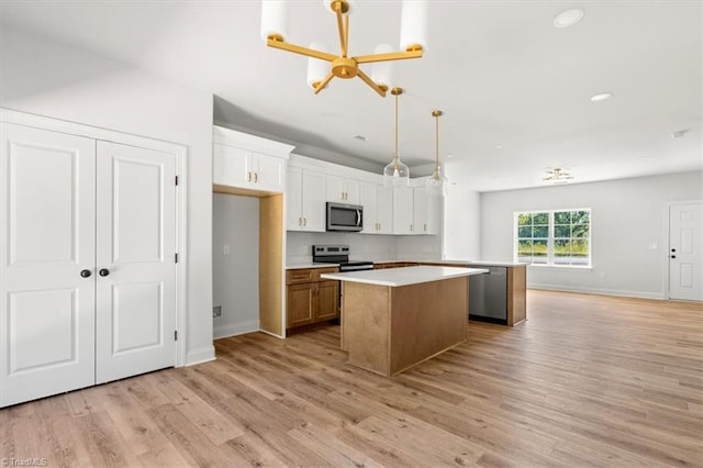 kitchen featuring white cabinets, light hardwood / wood-style flooring, stainless steel appliances, pendant lighting, and a center island