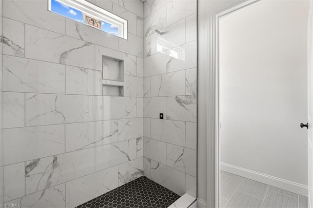 bathroom featuring a tile shower and tile patterned flooring