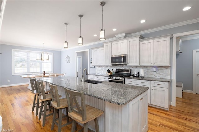 kitchen featuring white cabinetry, appliances with stainless steel finishes, sink, and an island with sink