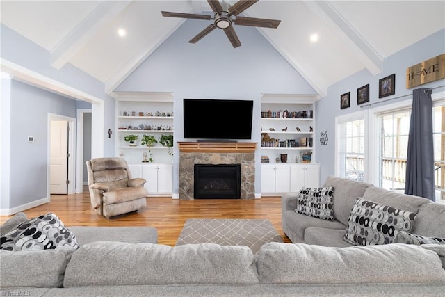 living room with beamed ceiling, high vaulted ceiling, and light hardwood / wood-style floors