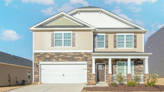 craftsman inspired home featuring concrete driveway, stone siding, an attached garage, central air condition unit, and a porch